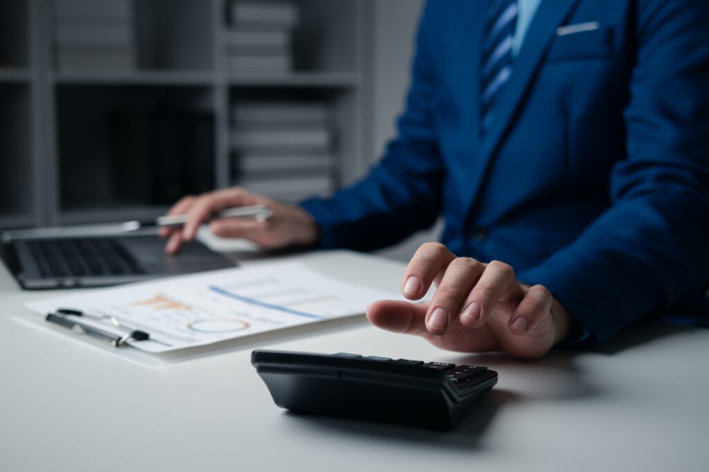 Close up businessman hand using calculator and working with laptop calculate about finance account