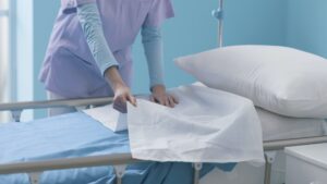 Expert young nurse making the bed at the hospital
