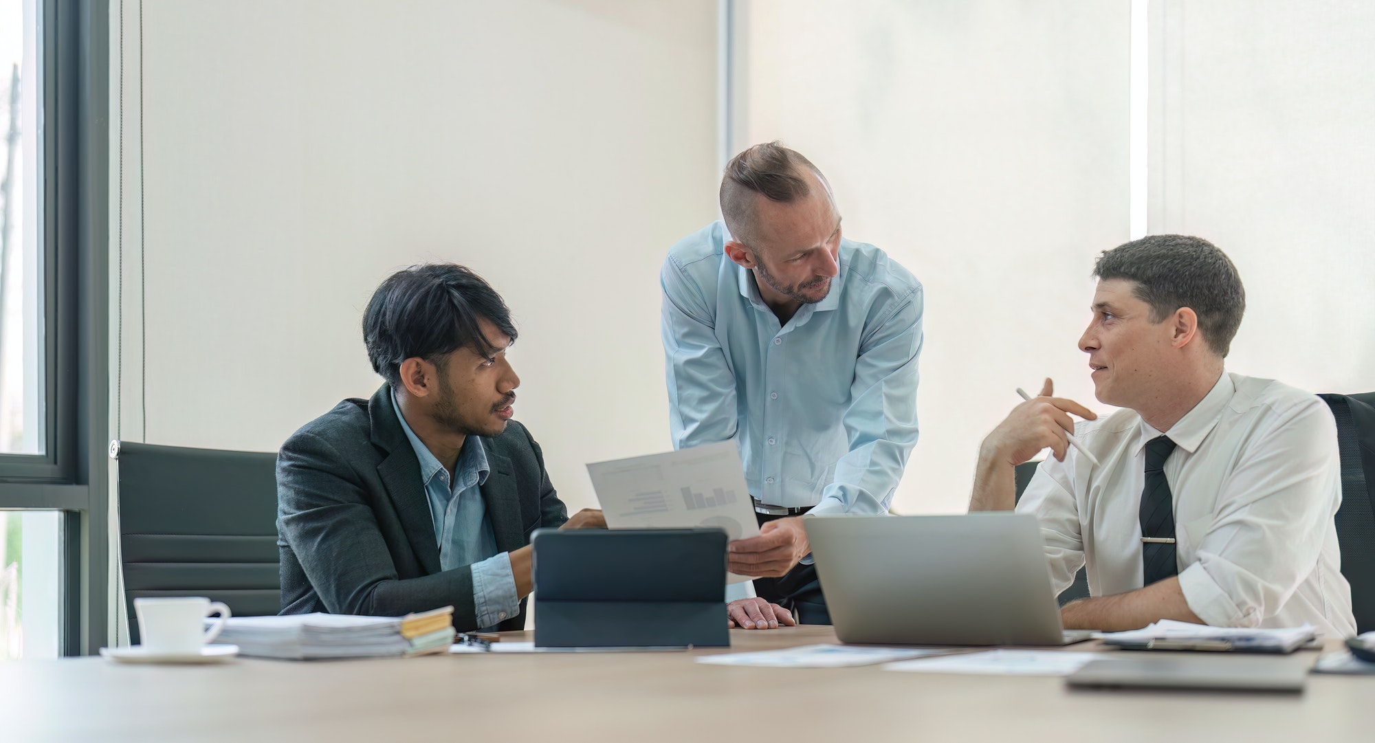 Business team discussing online project, showing computer presentation to skilled team leader